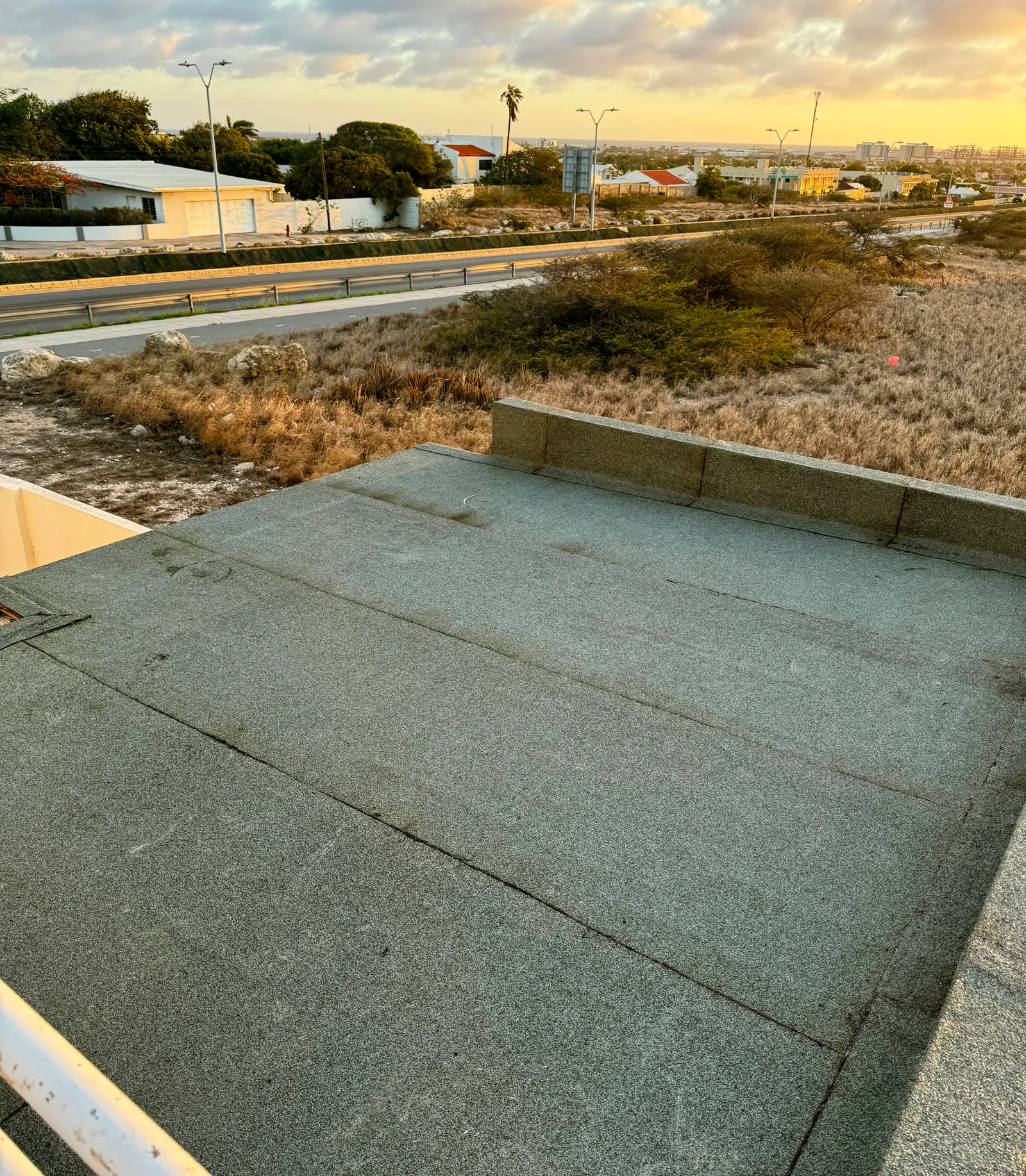 Torch-on membrane flat roof at golden hour with clean welded edge lines