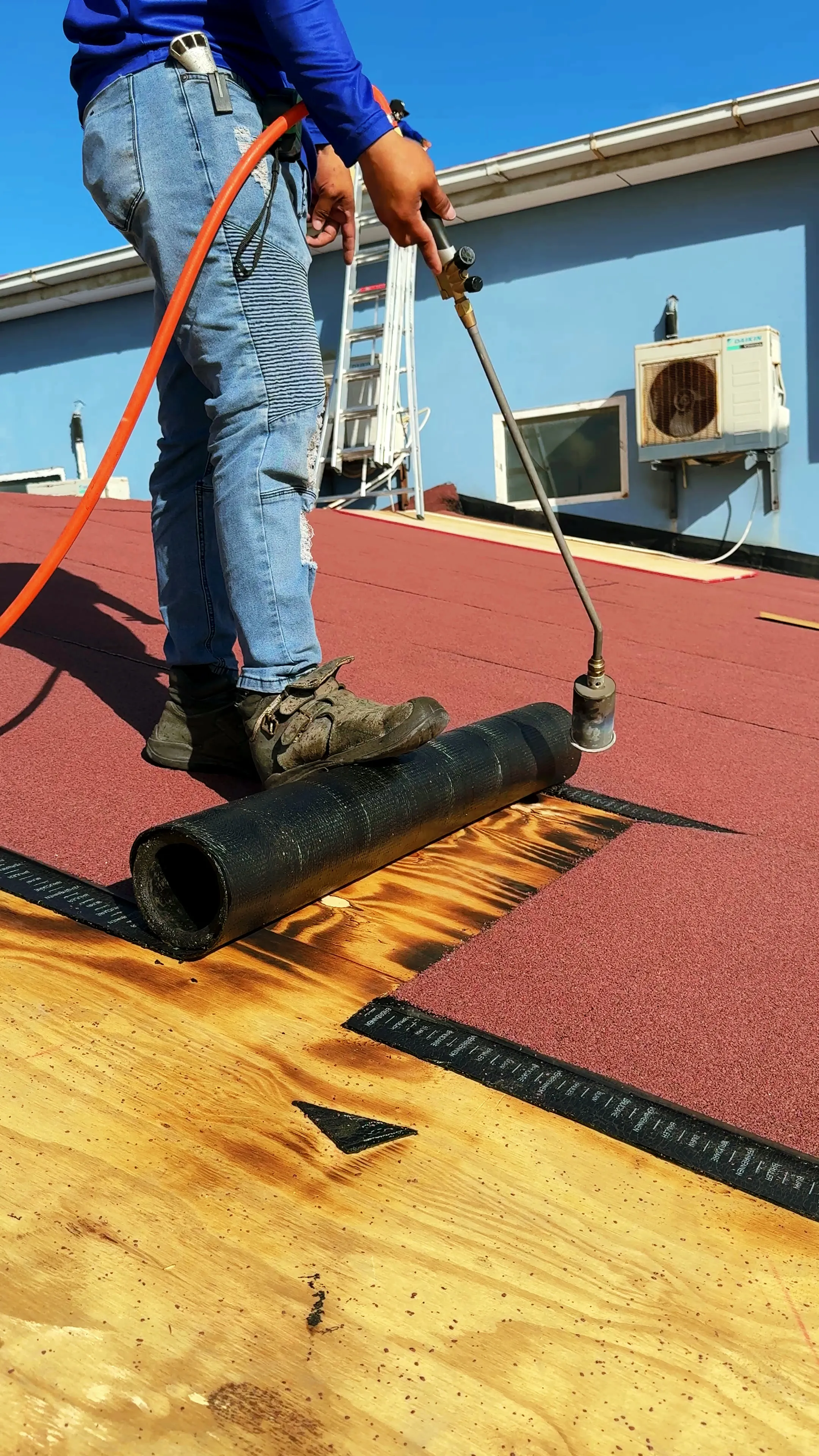 Torch-on membrane being applied on a plywood deck, our crew